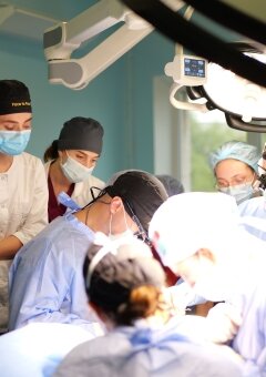 Dr. Ryan Winters with Dr. Vitaliy Panchenko are performing a forehead free flap. They are surrounded with the Ukrainian doctors and residents which are watching the surgery.