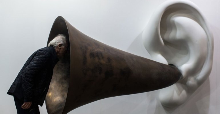 A visitor peering into John Baldessari’s “Beethoven’s Trumpet (With Ear) 
